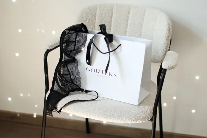 Torba prezentowa Gorteks z kokardką i biustonoszem. Czarny koronkowy stanik jako prezent dla kobiet